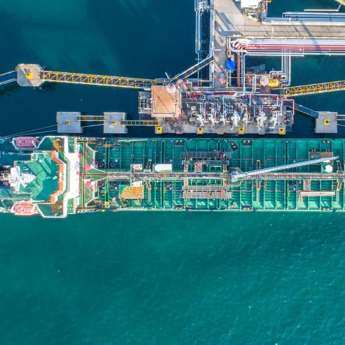 Top-down view of cargo ship being refueled and loaded